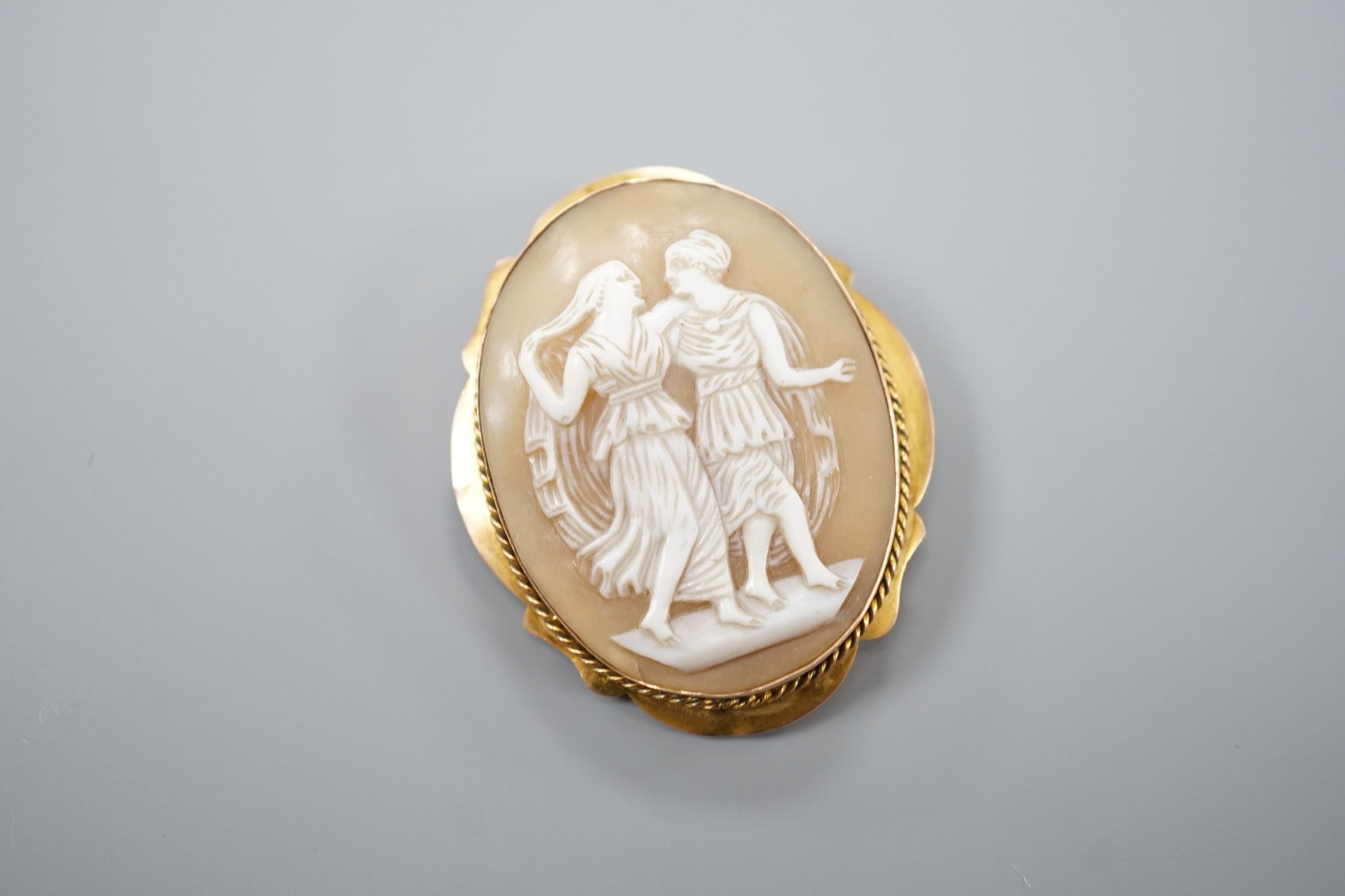 A 9ct mounted oval cameo shell brooch, decorated with two maidens, 46mm, gross 8.9 grams.